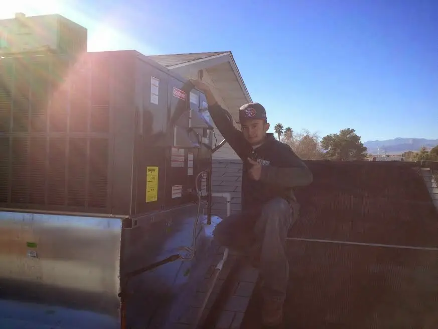 HVAC technician performing Boiler Repair on a rooftop unit in Summit